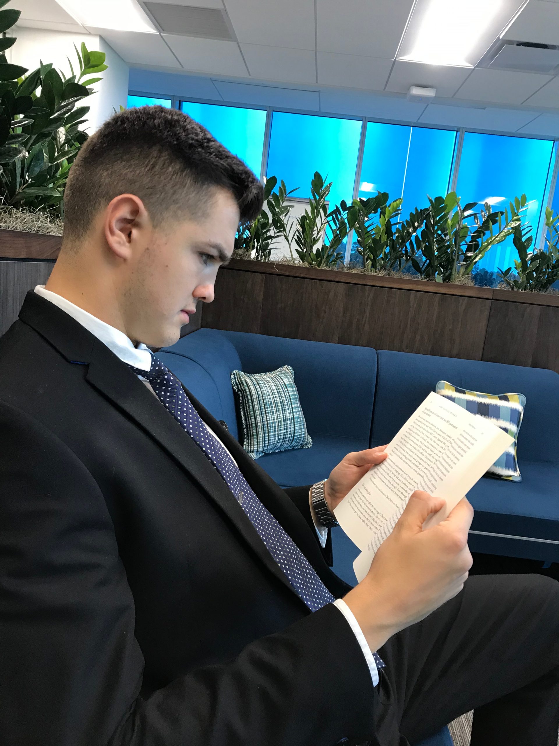 Marko Ceki practicing focused learning and deep work while reading in a modern office setting.